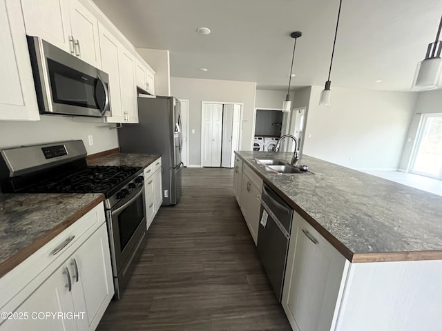 49045 Gemini Ct, Soldotna, AK 99669 - kitchen featuring a large island, white cabinets, a sink, dark wood finished floors, and appliances with stainless steel finishes