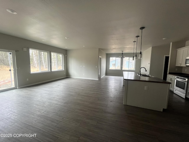 49045 Gemini Ct, Soldotna, AK 99669 - kitchen with white cabinets, dark countertops, appliances with stainless steel finishes, a sink, and open floor plan