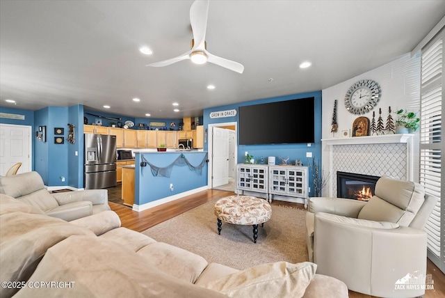 222 E 7th Ave # 106, Anchorage, AK 99501 - living area with recessed lighting, ceiling fan, a tiled fireplace, and wood finished floors