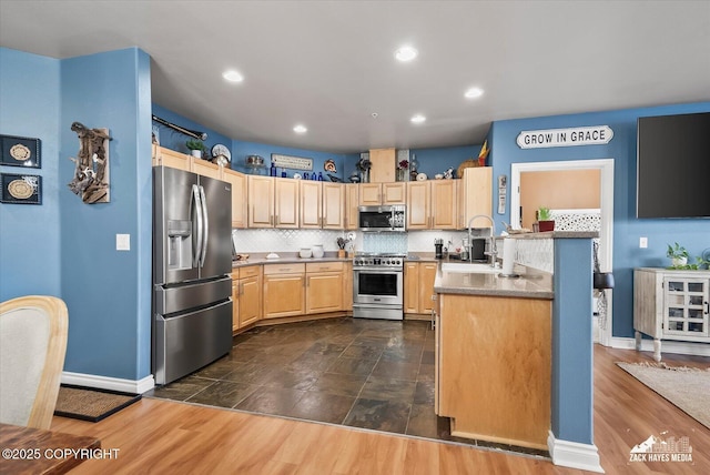 222 E 7th Ave # 106, Anchorage, AK 99501 - kitchen with appliances with stainless steel finishes, a sink, light brown cabinets, baseboards, and backsplash