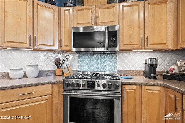 222 E 7th Ave # 106, Anchorage, AK 99501 - kitchen with backsplash, stainless steel appliances, dark countertops, and light brown cabinets
