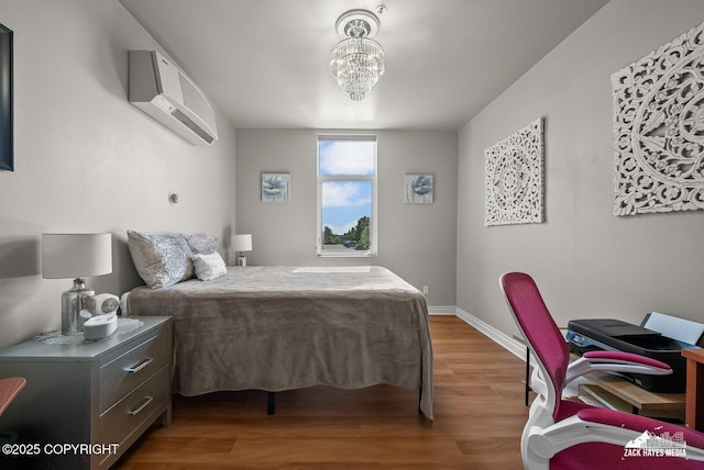 222 E 7th Ave # 106, Anchorage, AK 99501 - bedroom with a wall mounted AC, wood finished floors, and a chandelier