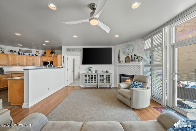 222 E 7th Ave # 106, Anchorage, AK 99501 - living room featuring recessed lighting, light wood-style floors, ceiling fan, and a tile fireplace