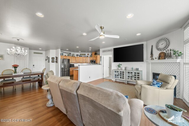 222 E 7th Ave # 106, Anchorage, AK 99501 - living area with recessed lighting, a chandelier, a ceiling fan, light wood finished floors, and a fireplace