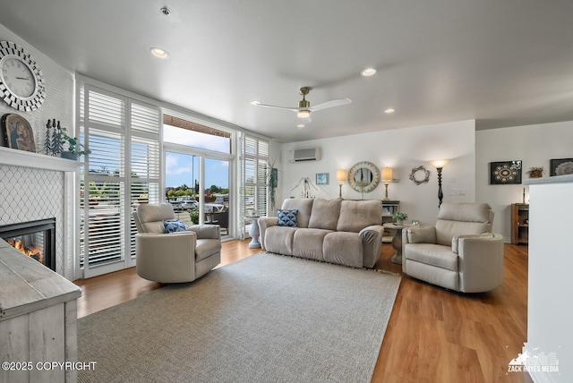 222 E 7th Ave # 106, Anchorage, AK 99501 - living area featuring an AC wall unit, a tile fireplace, wood finished floors, ceiling fan, and recessed lighting