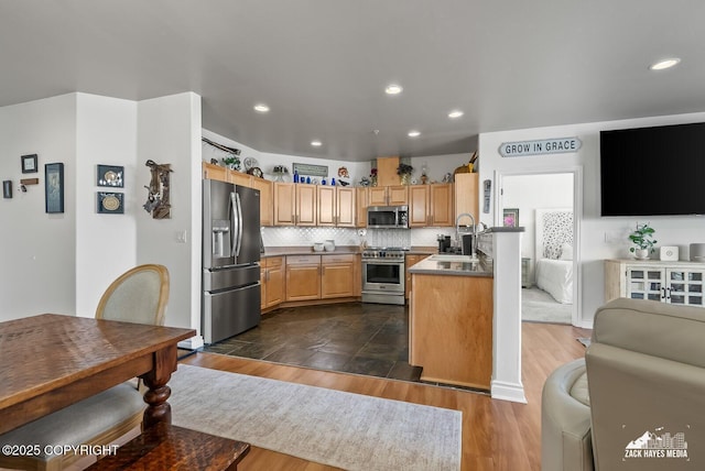 222 E 7th Ave # 106, Anchorage, AK 99501 - kitchen featuring appliances with stainless steel finishes, recessed lighting, dark wood-type flooring, decorative backsplash, and open floor plan