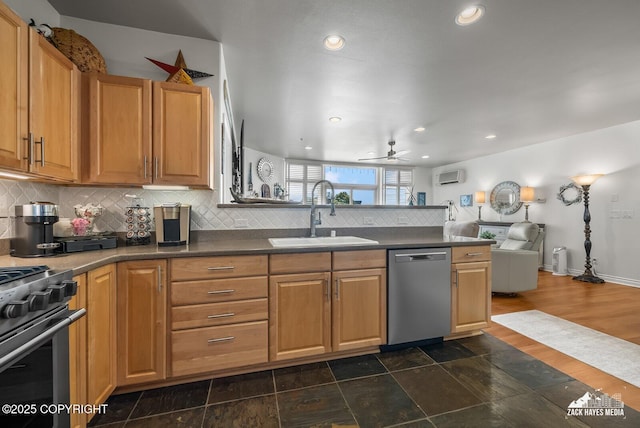222 E 7th Ave # 106, Anchorage, AK 99501 - kitchen featuring stainless steel appliances, ceiling fan, a peninsula, backsplash, and dark countertops