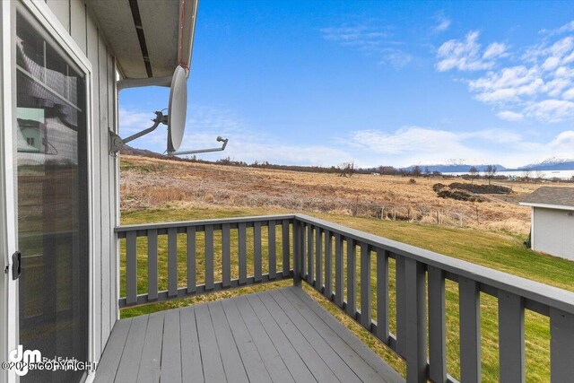 wooden deck featuring a yard and a mountain view