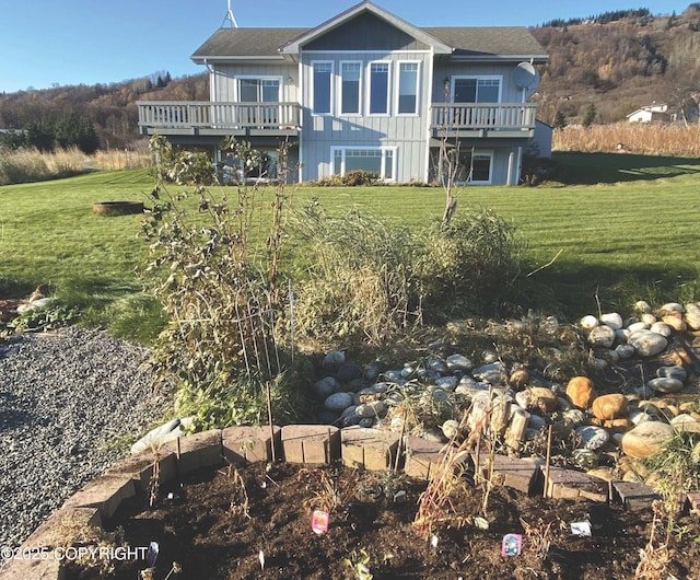 back of property featuring a yard and a deck