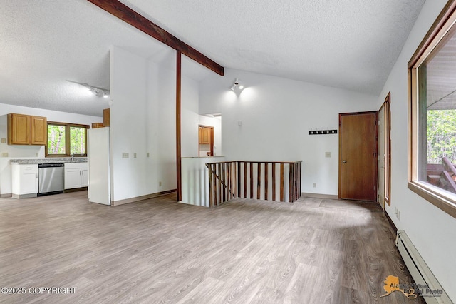 5900 E Liberty Ct, Wasilla, AK 99654 - unfurnished living room featuring a baseboard radiator, a textured ceiling, light wood finished floors, a sink, and healthy amount of natural light