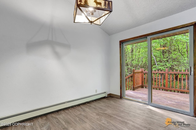 5900 E Liberty Ct, Wasilla, AK 99654 - unfurnished dining area with a baseboard heating unit, wood finished floors, a chandelier, lofted ceiling, and baseboards