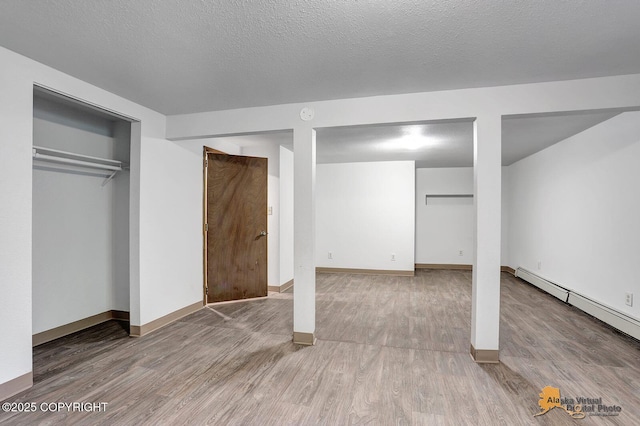 5900 E Liberty Ct, Wasilla, AK 99654 - unfurnished bedroom featuring wood finished floors, baseboard heating, and baseboards