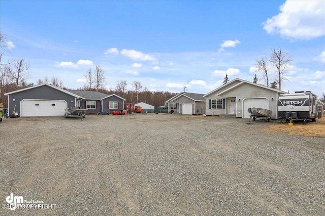 ranch-style house with an attached garage, an outbuilding, and driveway