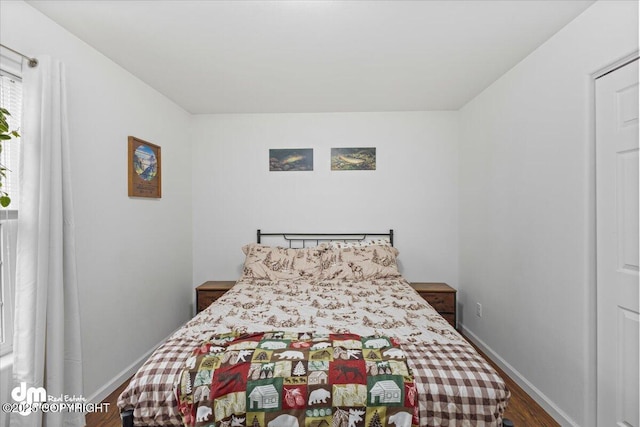 bedroom featuring baseboards and wood finished floors
