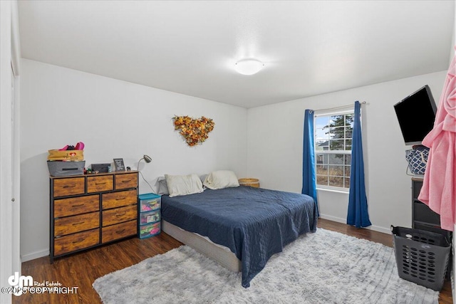 bedroom with baseboards and wood finished floors