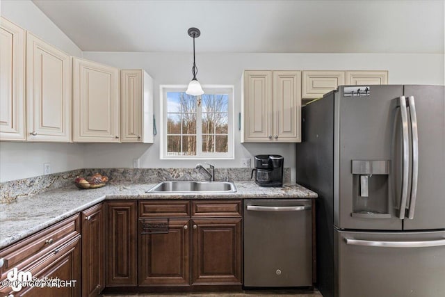 kitchen featuring a sink, pendant lighting, appliances with stainless steel finishes, and cream cabinets