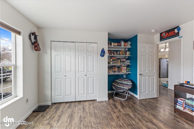 bedroom featuring baseboards, a closet, wood finished floors, and a notable chandelier
