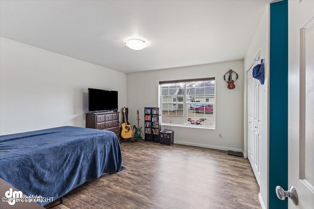 bedroom with baseboards and wood finished floors