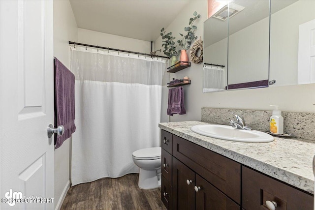 full bath with vanity, toilet, wood finished floors, and visible vents