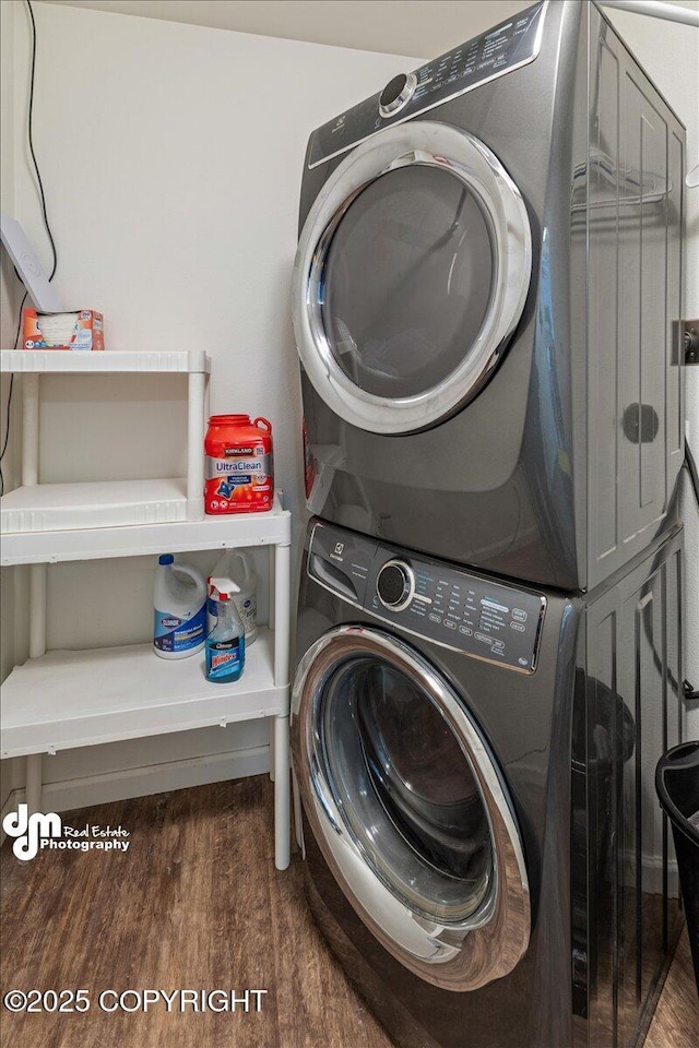 laundry area with laundry area, stacked washer / dryer, and wood finished floors