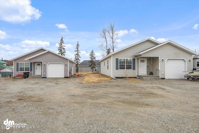 single story home featuring an attached garage and dirt driveway