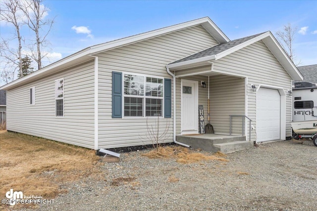 view of front of property with an attached garage, a shingled roof, and driveway