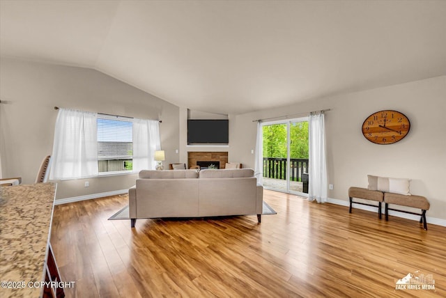 13050 Curry Ridge Cir, Eagle River, AK 99577 - living area with lofted ceiling, light wood-type flooring, a fireplace, and baseboards