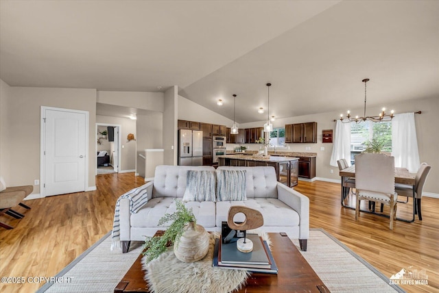 13050 Curry Ridge Cir, Eagle River, AK 99577 - living room featuring a chandelier, light wood-type flooring, lofted ceiling, and baseboards