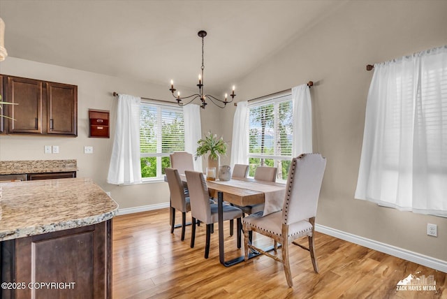 13050 Curry Ridge Cir, Eagle River, AK 99577 - dining room featuring a chandelier, healthy amount of natural light, baseboards, light wood-style flooring, and lofted ceiling