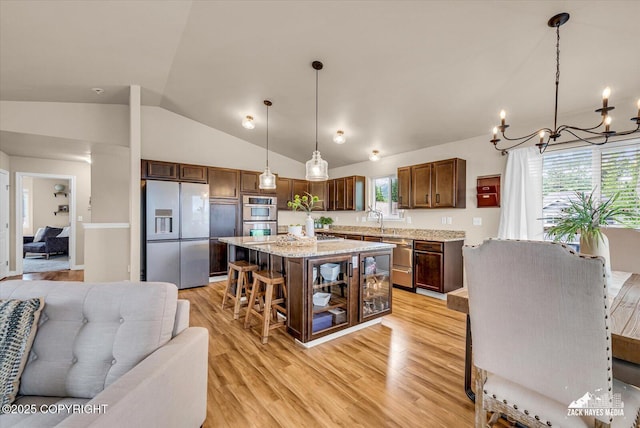13050 Curry Ridge Cir, Eagle River, AK 99577 - kitchen with stainless steel appliances, open floor plan, a chandelier, vaulted ceiling, and light wood-style floors