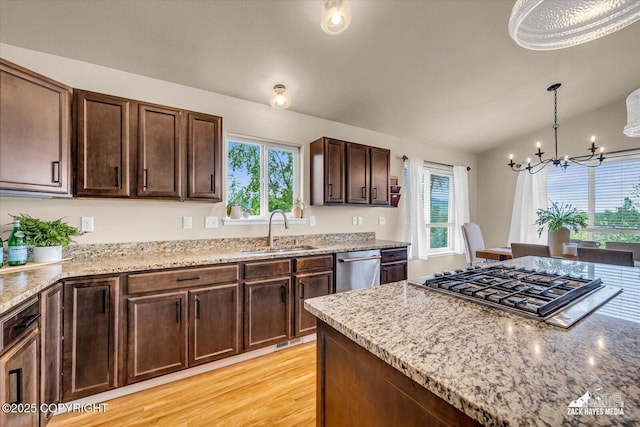 13050 Curry Ridge Cir, Eagle River, AK 99577 - kitchen featuring a sink, appliances with stainless steel finishes, a chandelier, and light stone counters