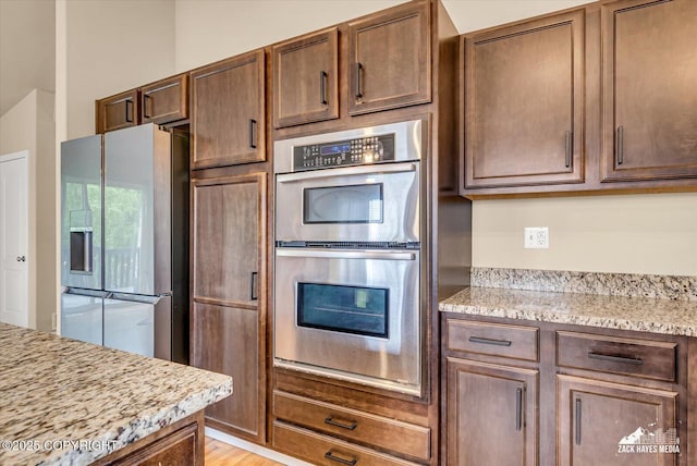 13050 Curry Ridge Cir, Eagle River, AK 99577 - kitchen featuring stainless steel appliances, light stone countertops, and light wood finished floors