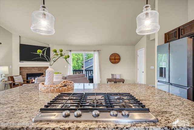13050 Curry Ridge Cir, Eagle River, AK 99577 - kitchen with appliances with stainless steel finishes, lofted ceiling, pendant lighting, dark brown cabinets, and a glass covered fireplace