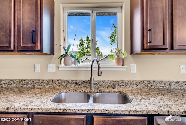 13050 Curry Ridge Cir, Eagle River, AK 99577 - kitchen view of a sink, dark brown cabinetry, and light stone countertops