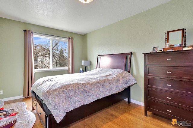 bedroom featuring baseboards and light wood-style flooring