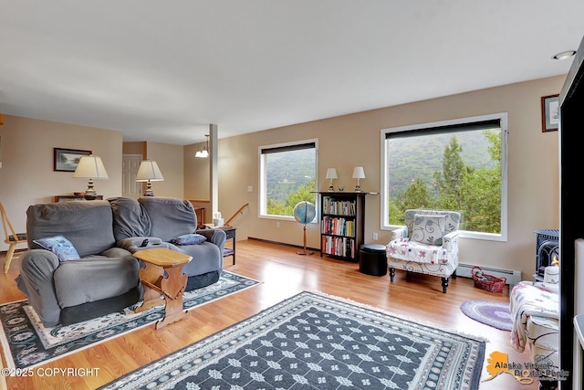 living area featuring wood finished floors, baseboard heating, and a wealth of natural light