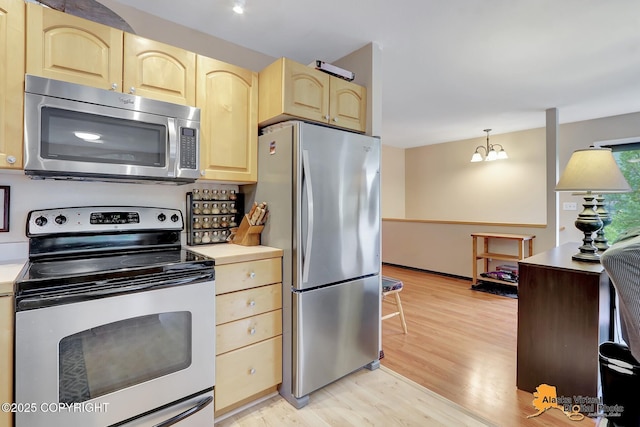 kitchen with light brown cabinetry, appliances with stainless steel finishes, light wood-style floors, and light countertops
