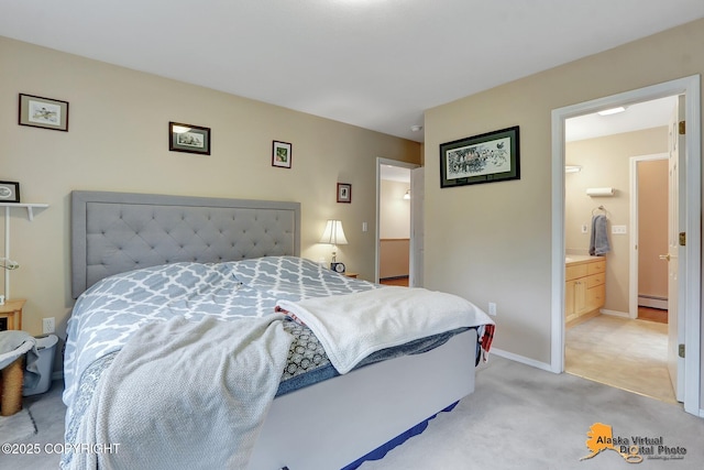 bedroom featuring baseboards, ensuite bath, baseboard heating, and light carpet