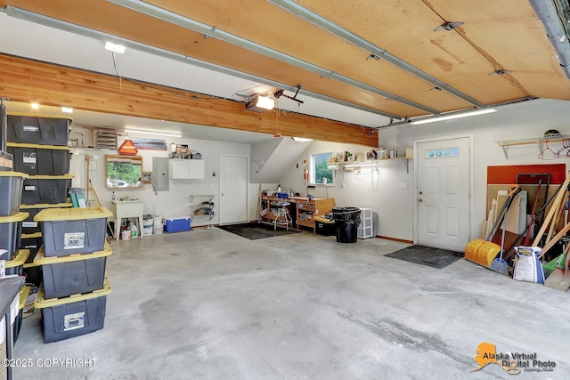 garage featuring a garage door opener, a sink, and electric panel