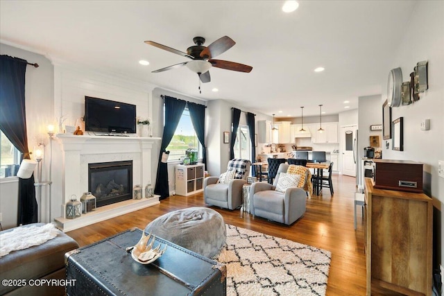 2153 S Withers Rd, Wasilla, AK 99654 - living area featuring ceiling fan, plenty of natural light, a glass covered fireplace, wood finished floors, and recessed lighting
