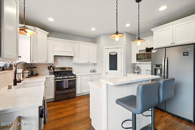 2153 S Withers Rd, Wasilla, AK 99654 - kitchen featuring appliances with stainless steel finishes, decorative backsplash, white cabinets, a breakfast bar area, and recessed lighting