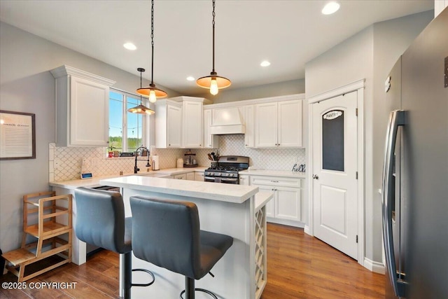 2153 S Withers Rd, Wasilla, AK 99654 - kitchen with appliances with stainless steel finishes, backsplash, white cabinetry, wood finished floors, and recessed lighting
