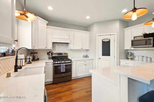 2153 S Withers Rd, Wasilla, AK 99654 - kitchen featuring appliances with stainless steel finishes, premium range hood, tasteful backsplash, white cabinets, and light stone countertops