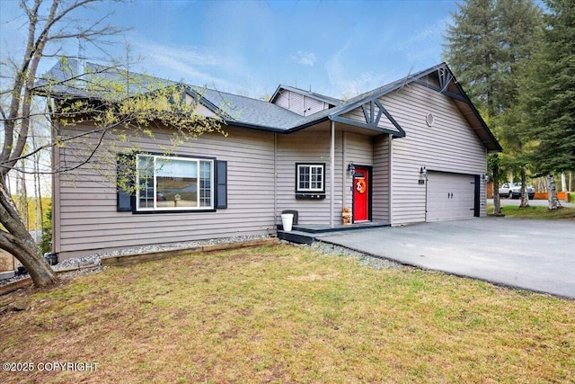 view of front of house with driveway, an attached garage, and a front yard