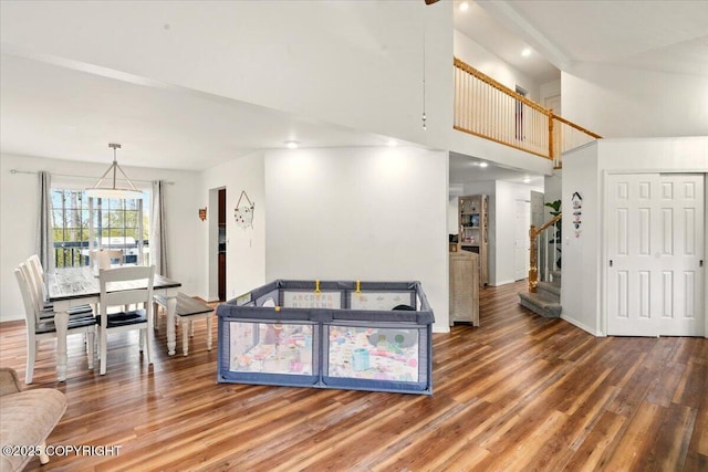 living room with wood finished floors, stairs, baseboards, a towering ceiling, and recessed lighting