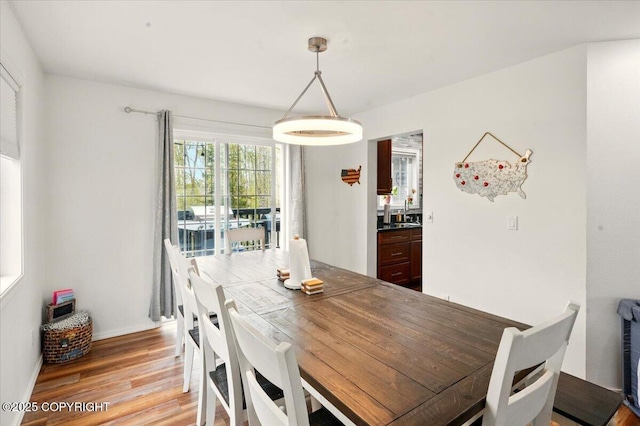 dining room featuring light wood-style floors and baseboards