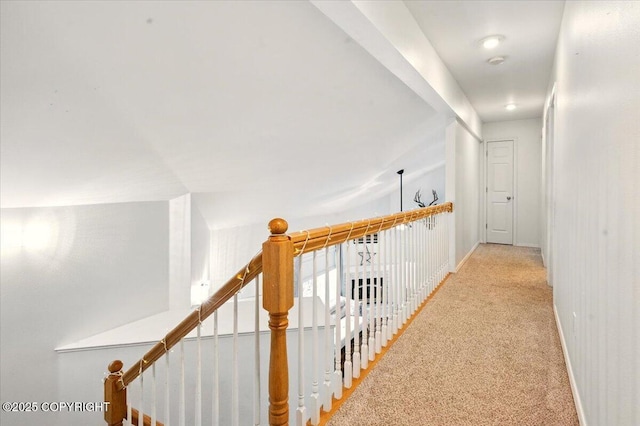 hallway featuring light carpet and baseboards
