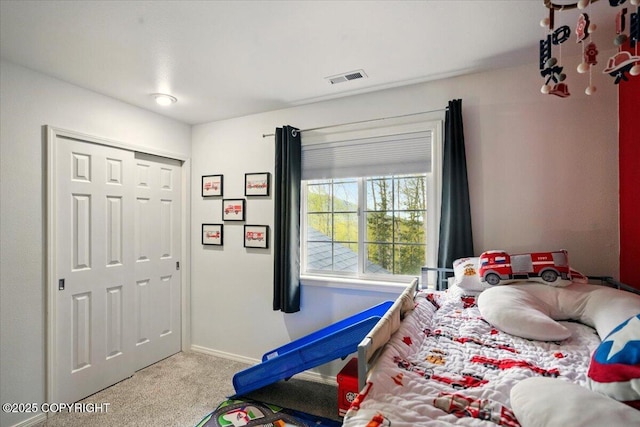 bedroom with carpet floors, baseboards, and a closet