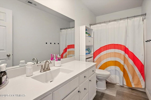 full bath featuring wood finished floors, vanity, and toilet