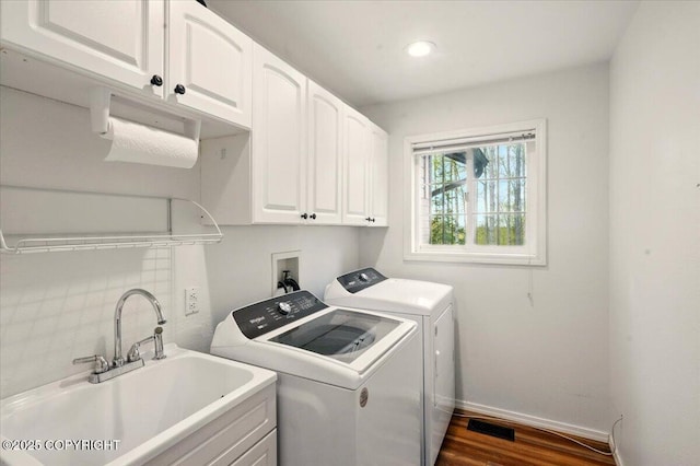 clothes washing area with cabinet space, washing machine and clothes dryer, baseboards, dark wood finished floors, and recessed lighting